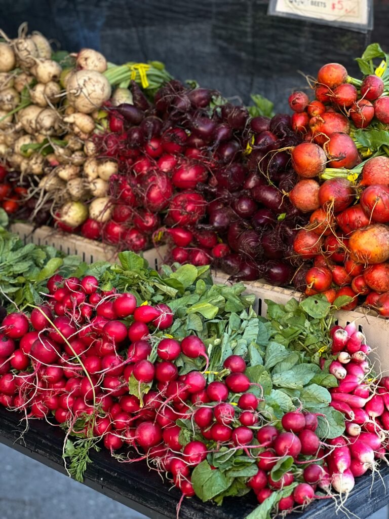 Colorful display of fresh radishes and root vegetables at a New York City market stand.