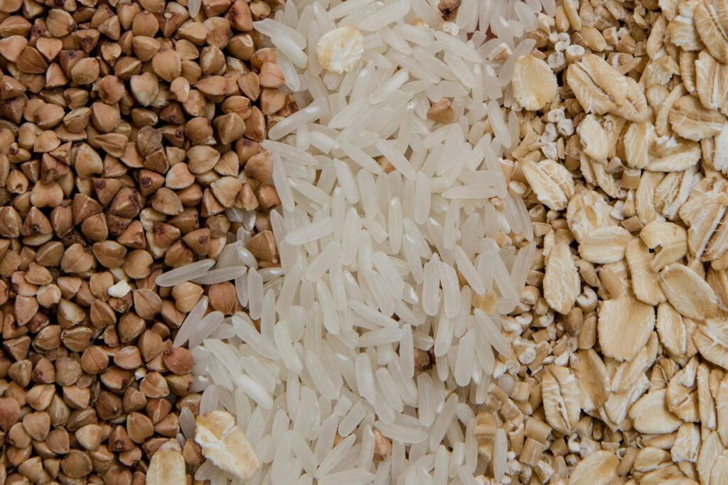 Close-up of assorted raw grains including buckwheat, rice, and oats, highlighting healthy food choices.